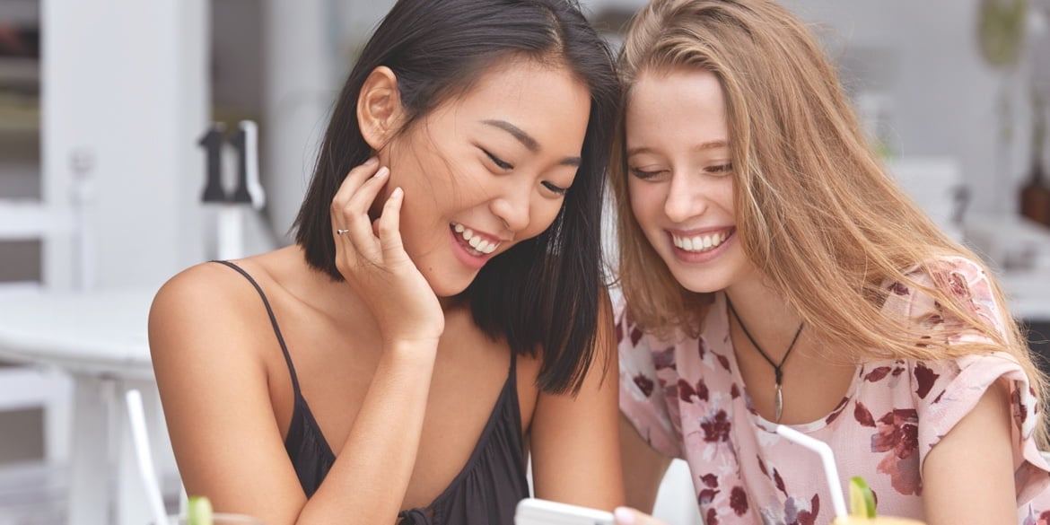 Two young women in their twenties looking at a phone