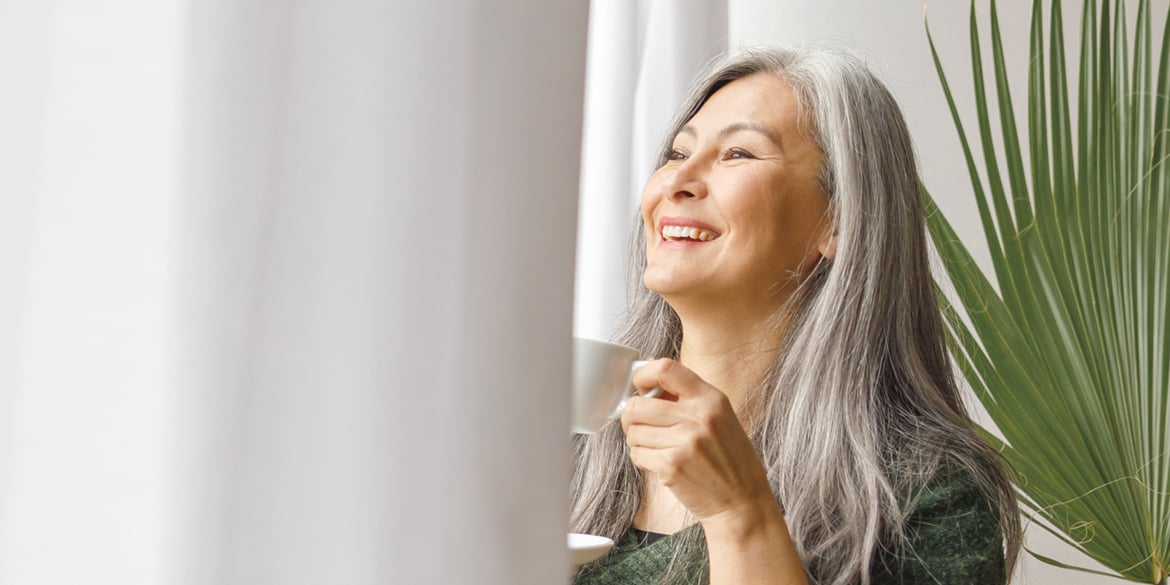 A woman in her 60's enjoying her beverage