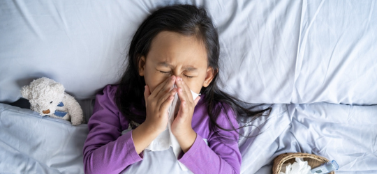 Asian child girl sick with sneezing on the nose and cold cough on tissue paper